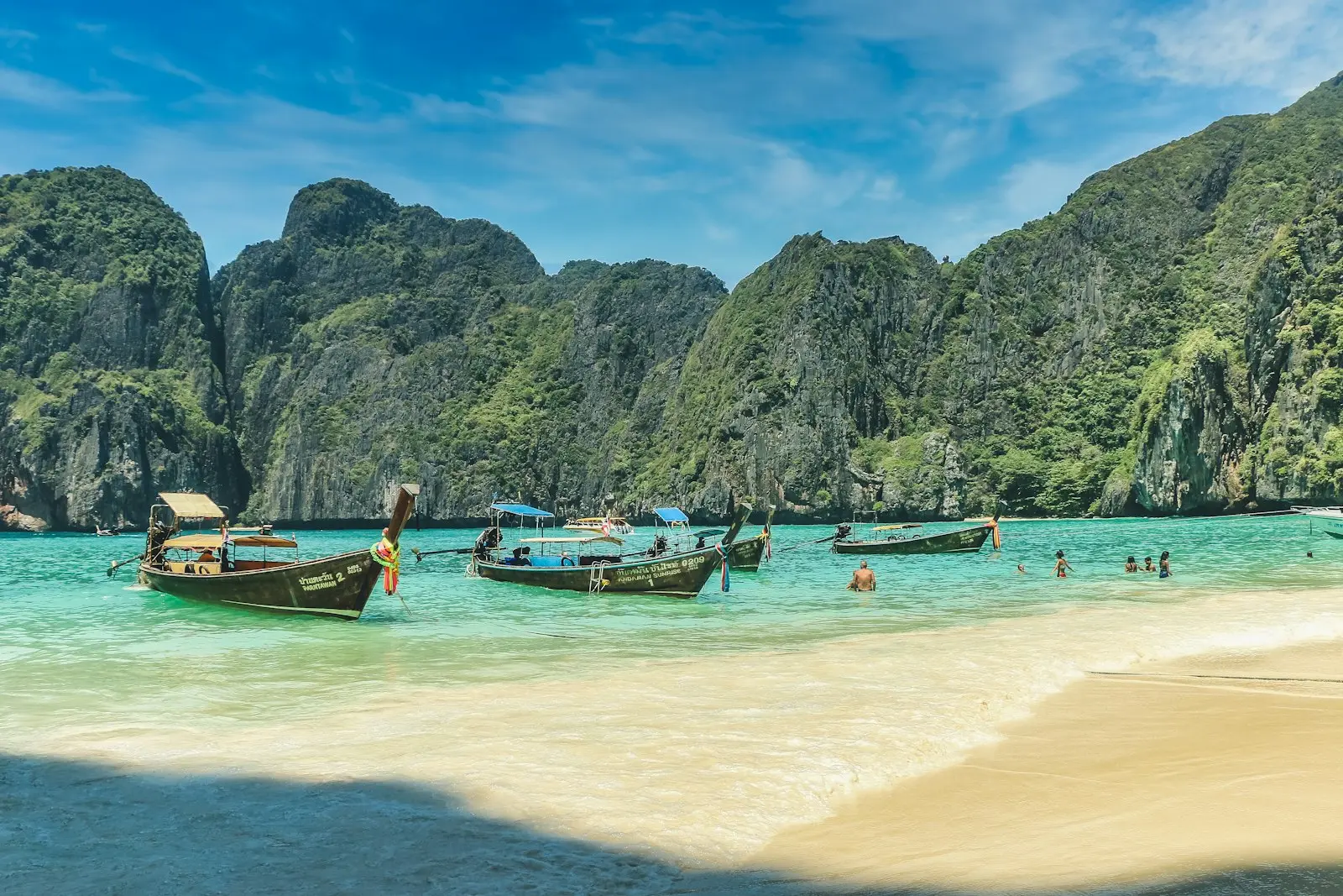 Plajă tropicală în Thailanda, cu apă turcoaz și bărci long-tail